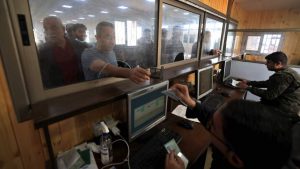 ضباط فلسطينيون يفحصون وثائق عمال ينتظرون الوصول إلى إسرائيل عبر معبر إيريز بعد إعادة فتحه في بيت حانون شمال قطاع غزة في 26 أبريل 2022.