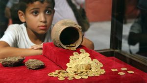 صبي-ينظر-إلى-العملات-المعدنية-المعروضة-في-معرض-عملات-عبر-العصور-في-المتحف-المصري-في-القاهرة