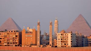 كنيسة السيدة العذراء مريم والقديس الأنبا رويس في حي حدائق الأهرام مع الأهرامات العظيمة في مقبرة أهرامات الجيزة في الخلفية ، في الضواحي الجنوبية الغربية للعاصمة المصرية القاهرة.