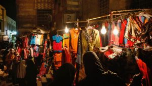 مصريون يتسوقون للملابس في سوق ليلي على درج مدرسة السلطان الغوري في أوائل القرن السادس عشر ، القاهرة ، مصر ، 21 فبراير 2009.