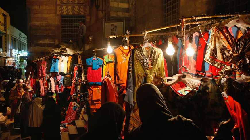 مصريون يتسوقون للملابس في سوق ليلي على درج مدرسة السلطان الغوري في أوائل القرن السادس عشر ، القاهرة ، مصر ، 21 فبراير 2009.